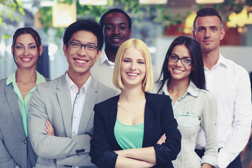 Happy group of co-workers standing in office-1 - global employee